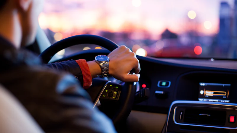 Driver at the wheel of a connected car at dusk